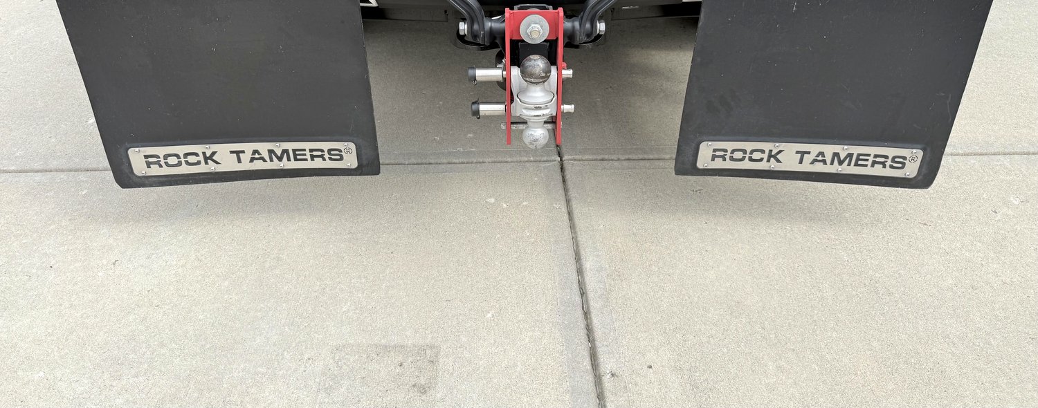 Both Rock Tamers mud flaps mounted directly to the hitch, full width, viewed head-on