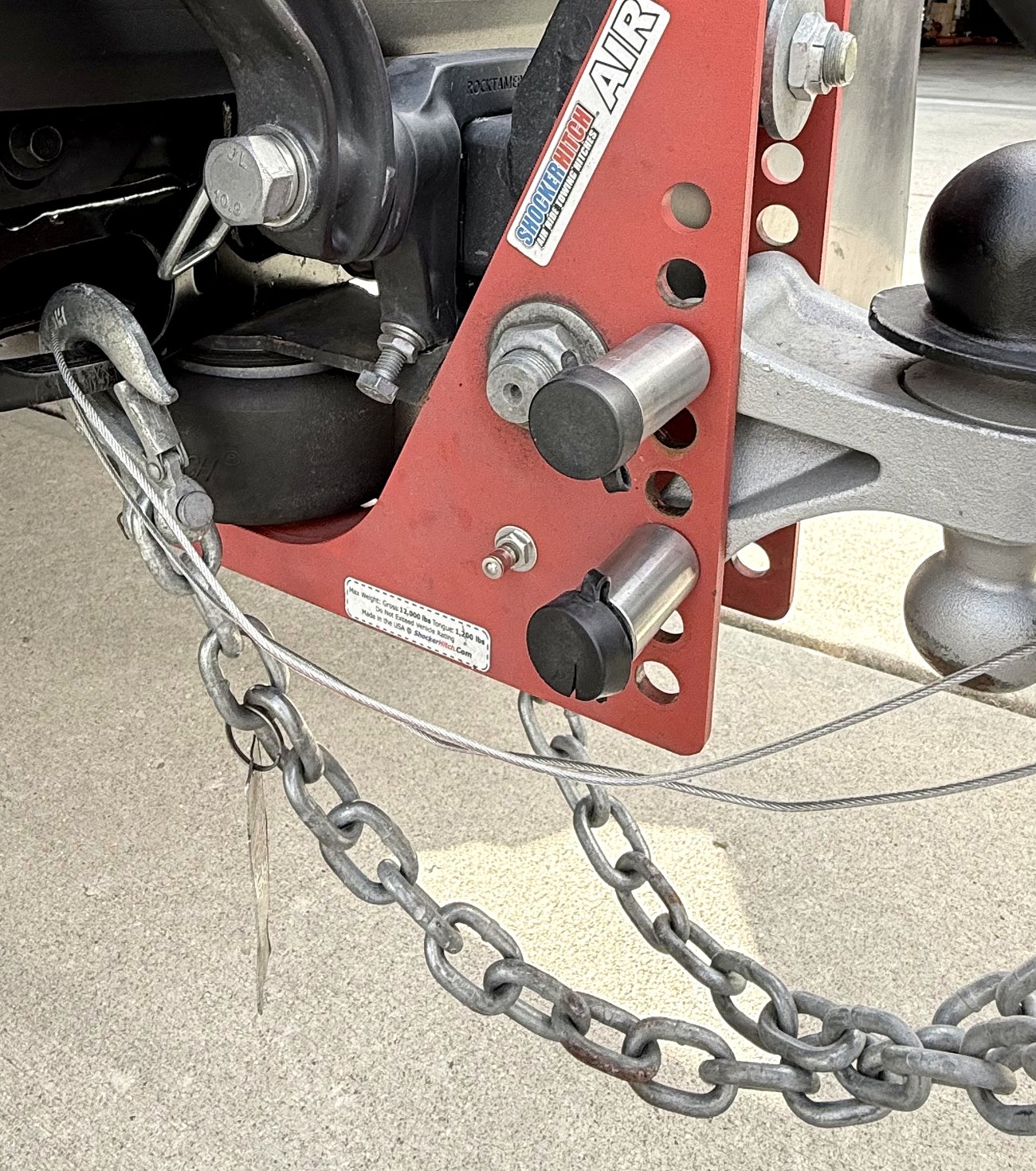 The Shocker Hitch Air coupled to the Airstream, with the chains crossed and the breakaway cable attached