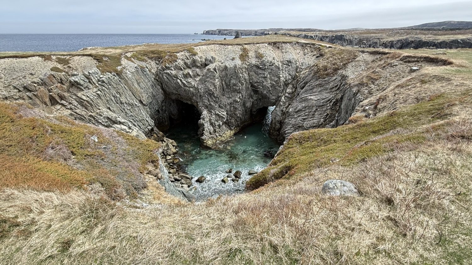 The Dungeon, a collapsed double sea cave with a natural stone archway over clear turquoise water