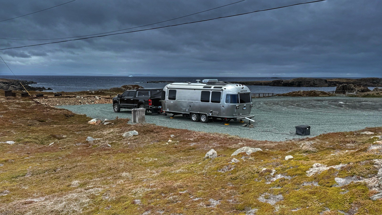 Dark storm clouds rolling in over our rig at Landfall Municipal Park, with the ocean and an iceberg visible in the distance