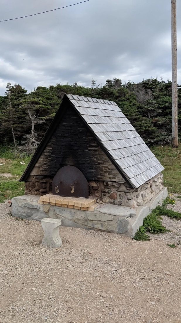 The stone and shingle-roofed Four à Pain, a traditional French community bread oven at Boutte du Cap Park