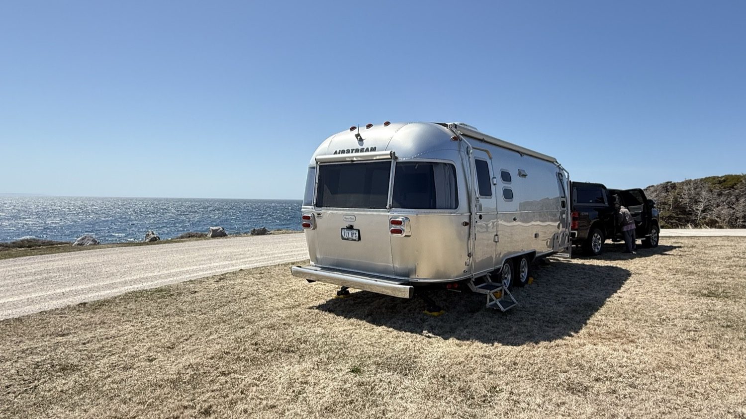 A closer view of our truck and Airstream parked at Boutte du Cap Park under a clear blue sky