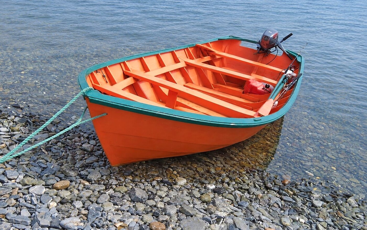 The orange and green traditional Newfoundland dory we fished from, beached on the rocky shore