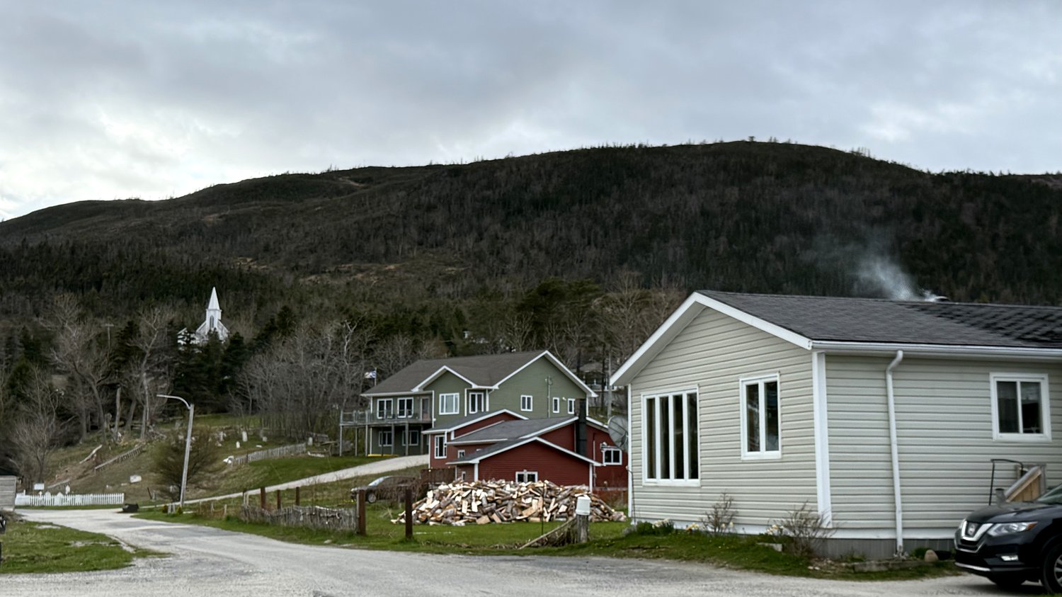 Quaint homes in the small town of Cox Cove, with a white church steeple visible against the hillside