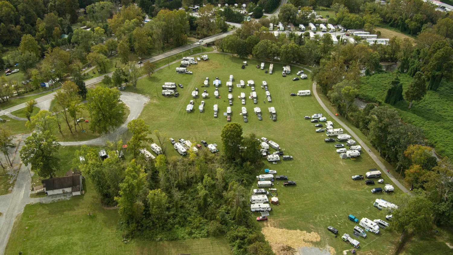 An aerial view of Frog Level Park, with rows of Airstreams and trucks in the center of the field and other campers around the edges
