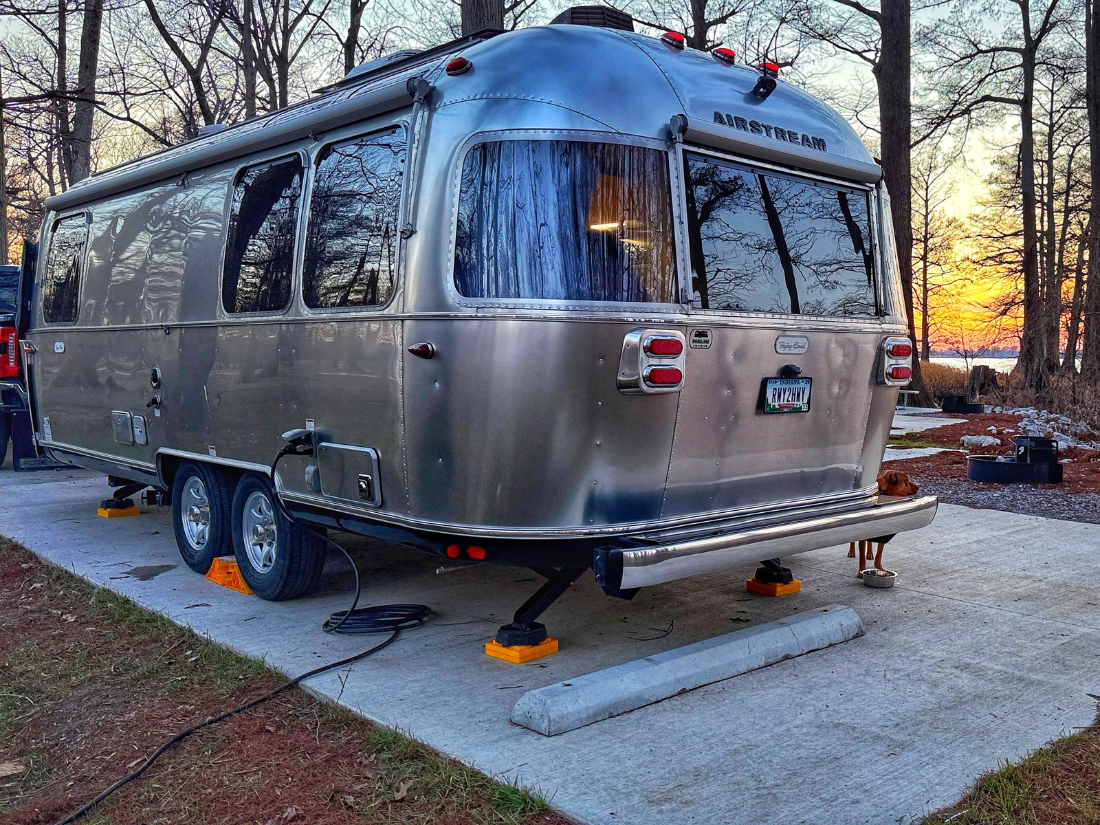 Their Airstream at golden hour, with one of the dogs on guard by his food bowl