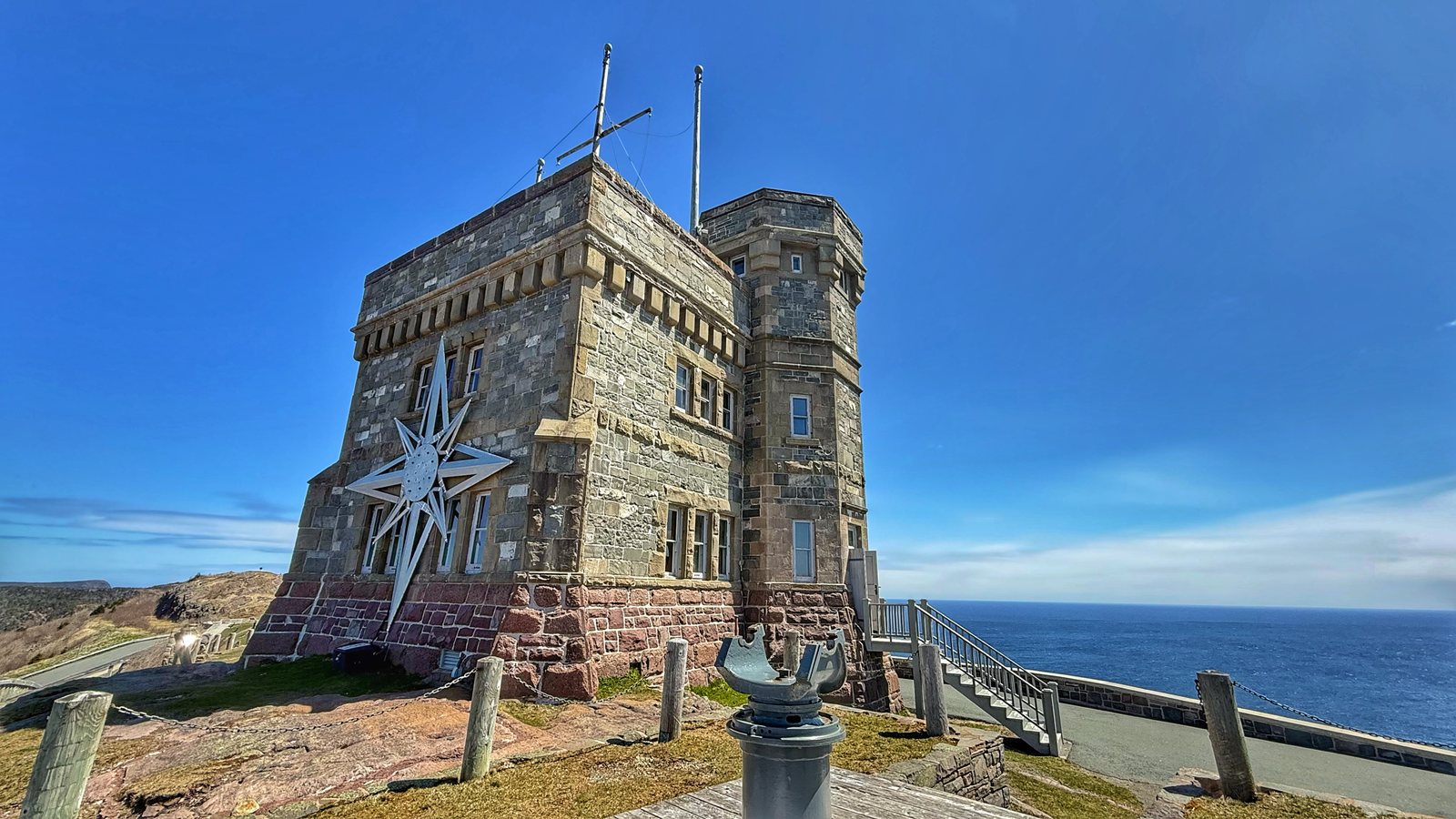 Cabot Tower from the other side, with a large white star on its stone wall and the dark blue Atlantic beyond