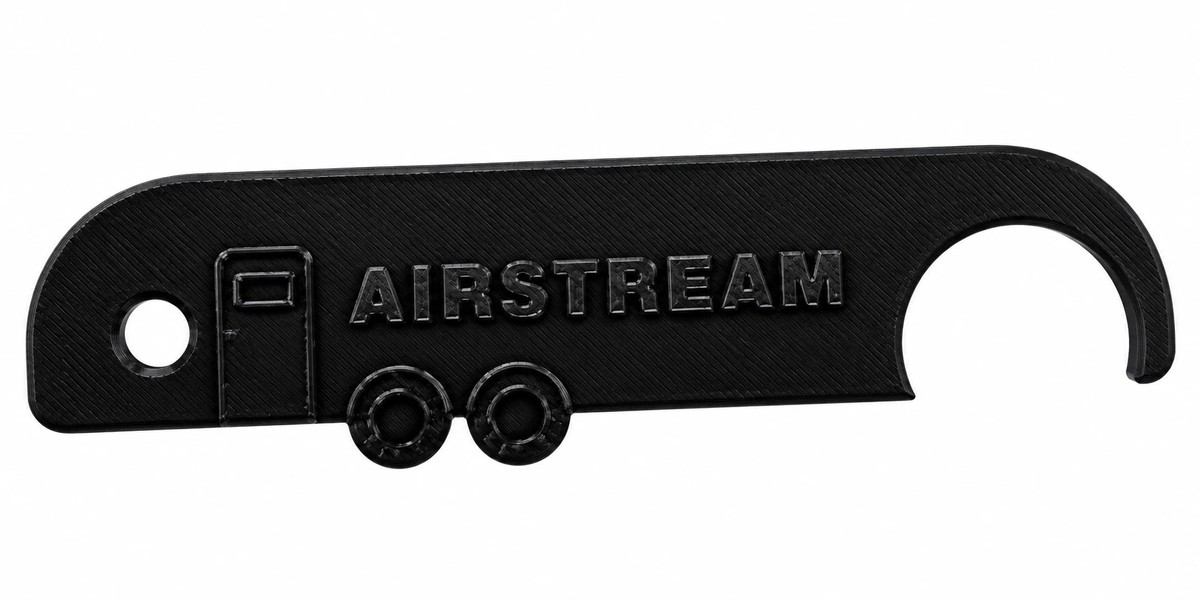 The Gear Pin, a black 3D-printed tool shaped like a travel trailer with a hook on one end